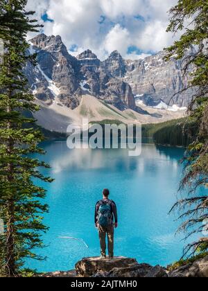 Escursionista guardando la vista al Lago Moraine durante l'estate nel Parco Nazionale di Banff, Canadian Rockies, Alberta, Canada.
