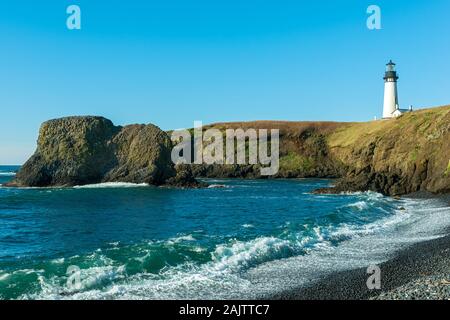 Il Yaquina Capo Faro sopra l'Oceano roccioso litorale a Newport, Oregon, Stati Uniti d'America Foto Stock