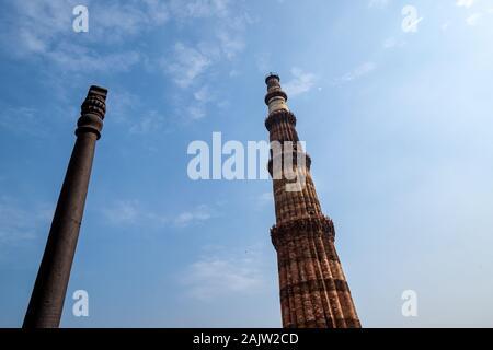 Famosa Colonna di ferro con la Qutub Minar minareto columb a Nuova Delhi, India, situata nel cortile del Quwwatu'l-Islam moschea Foto Stock