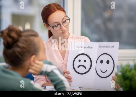 Insegnante di concentrato che mostra il suo allievo di test psicologici Foto Stock