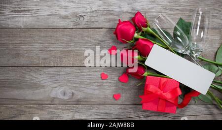 Il giorno di San Valentino card. Una confezione regalo rossa con due bottiglie di champagne di con e una nota Foto Stock