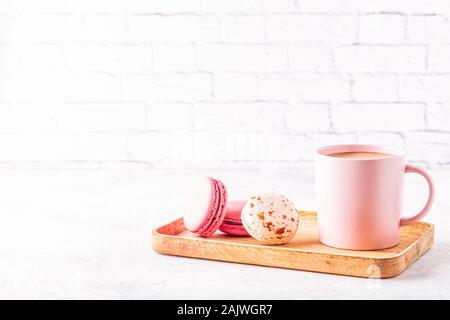 Amaretti francese e la tazza di caffè su un vassoio in legno Foto Stock