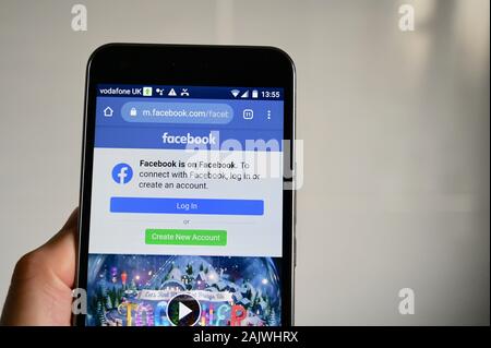 Telefono cellulare che visualizza Facebook Accedi o crea una nuova pagina Web dell'account. Foto Stock