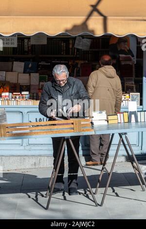 Navigando attraverso la seconda mano libri sulla Cuesta de Moyano, Madrid, Spagna Foto Stock