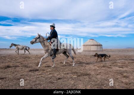 Cavalli che corrono nel villaggio di Kirghizistan e tenda tradizionale di Kirghizistan Foto Stock