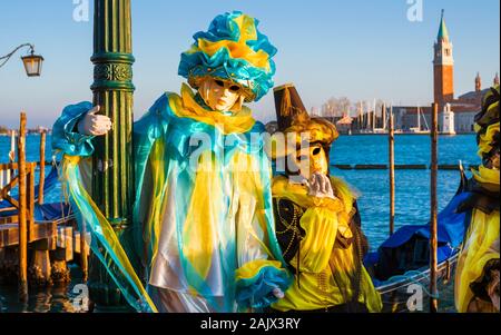 Carnevale a Venezia. Belle maschere veneziane con St George Island, laguna e gondole Foto Stock