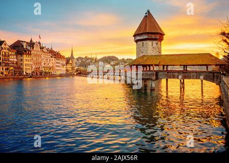 Lucerna Centro storico, la Svizzera, la vista del Ponte della Cappella in legno e alla torre d'acqua sulla drammatica sunrise Foto Stock