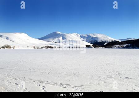 Bellissimo paesaggio innevato con le montagne vulcaniche e il lago ghiacciato durante il periodo invernale Foto Stock