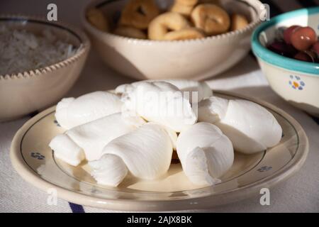 Mozzarella Fresca, tradizionalmente meridionali italiani formaggio di latte italiano dalla pasta filata metodo in un tradizionale piatto di terracotta Foto Stock