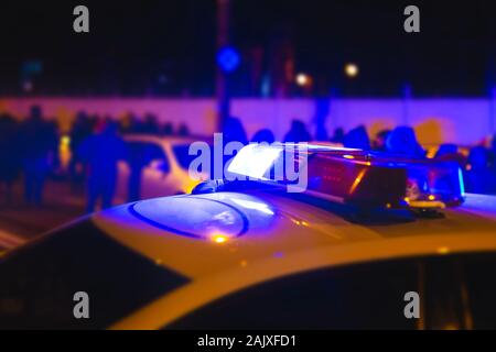 Luci di polizia. Lampeggiatore blu sulla macchina della polizia di notte. Le unità di polizia di rispondere alla scena di una manifestazione in strada. Concentrarsi sulle luci di polizia Foto Stock