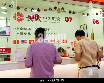 CHINATOWN, Singapore - 26 dic 2019 - Vista di cittadini cinesi presso il bancone di un trasferimento di denaro azienda specializzata nella cessione di denaro da Singapo Foto Stock