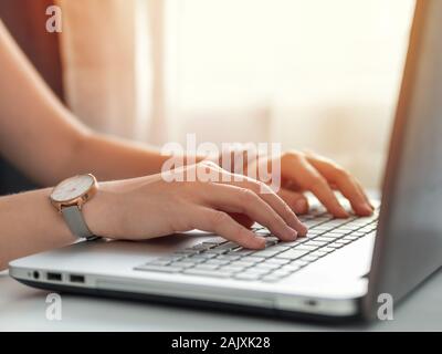 Lavorando da casa, imprenditore, freelance, social media, marketing sociale concetto. Close-up donna con le mani in mano la digitazione sulla tastiera portatile a casa. Copia spazio per il testo o per la progettazione Foto Stock