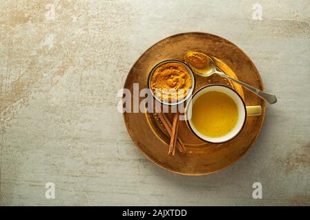 Bibita salutare realizzato da radici di curcuma, spezie, il latte e il miele. Golden latte, fatta con la curcuma e altre spezie Foto Stock