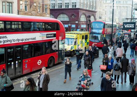 NHS ambulanza bloccata tra red double decker bus nella congestione del traffico nei pressi di Oxford Circus su Oxford Street a Londra England Regno Unito KATHY DEWITT Foto Stock