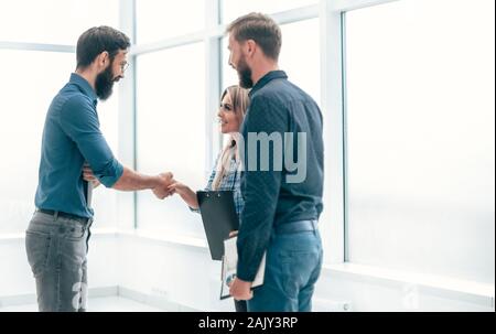 Giovani imprenditori che stringono le mani gli uni con gli altri Foto Stock