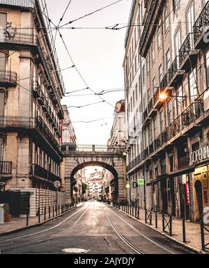 Vista di Rua de S. Paulo a Lisbona con i binari del tram e arch. Foto Stock