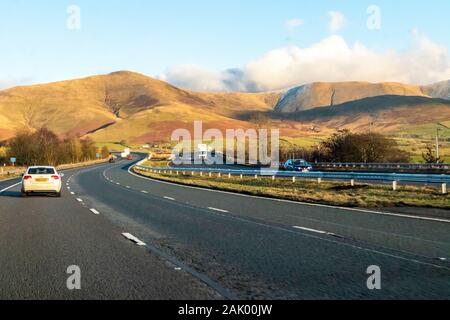 Passando attraverso il bordo del Lake District inglese su un inverno di pomeriggio andando verso nord sulla M6 Sud di Tebay, Cumbria Regno Unito Foto Stock