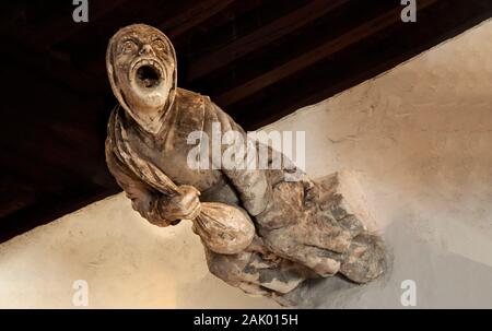 Gargoyle nella forma di un monaco medioevale tenendo un sacco dal castello reale di Blois. La Francia. Gargoyle gotica come l uomo medievale. Vecchia gargoyle vintage Foto Stock