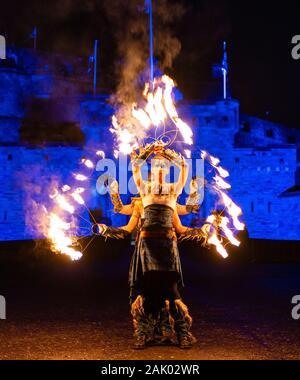Fire artisti che partecipano a Hogmanay processione aux flambeaux eseguire presso il Castello di Edimburgo prima della processione lungo il Royal Mile nel centro storico della città , SCO Foto Stock