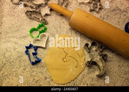 L'impasto e cookie cutter con un rotolo di carta da cucina di una farina per cuocere i biscotti per Natale Foto Stock