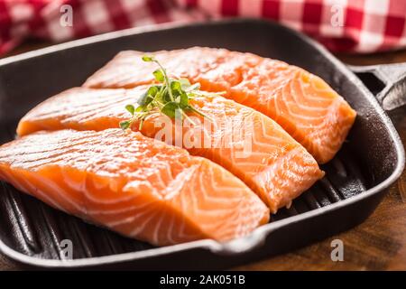 Crudo fresco di filetti di salmone serviti in ghisa padella per grigliare Foto Stock