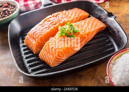 Crudo fresco di filetti di salmone serviti in ghisa padella per grigliare Foto Stock