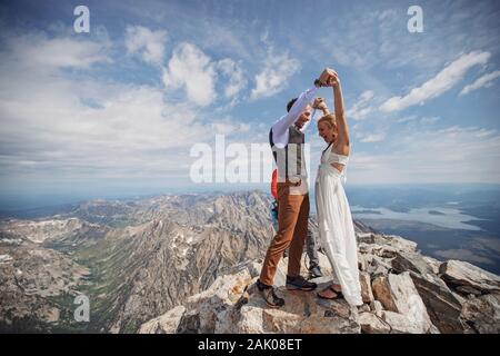 Sposa e Ginestra festeggiano dopo essersi sposati sulla cima della montagna Foto Stock