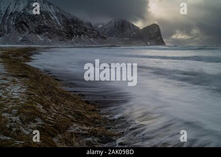 Grandi ondate di tempesta invernale casusing erosione nelle dune costiere, Unstad beach, Vestvågøy, Isole Lofoten in Norvegia Foto Stock