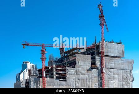 I lavoratori stanno lavorando sui siti di costruzione in acciaio strutturale trave costruire grandi edifici residenziali. Foto Stock