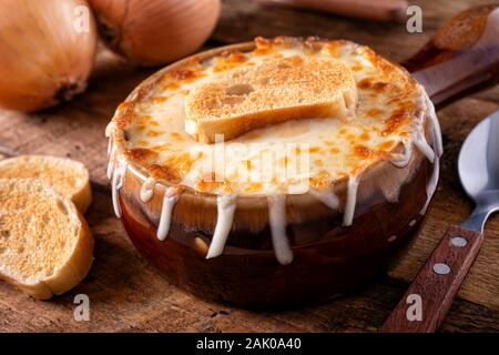Una ciotola di una deliziosa zuppa di cipolle alla francese con formaggio gruviera e baguette tostato. Foto Stock