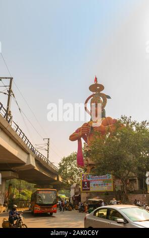 Traffico cittadino che domina Il tempio di Hanuman vicino Karol Bagh Delhi con uno statuto gigante di 108 piedi di Lord Hanuman . Foto Stock