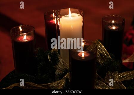 Viola avvento candele e il bianco Cristo candela in centro a bruciare in una chiesa alla vigilia di Natale. Foto Stock