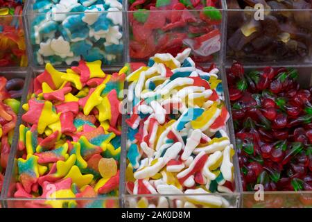 Caramelle di gomma in tutti i tipi di colori e sapori. In forma di cuori, orsetti, banane, stelle, serpenti e molto di più. Gustosi piatti freschi e buoni. Foto Stock