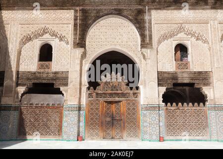 Ornamenti impressionanti (tra cui zellige e muqarnas) sul cortile di Bou Inania Madrasa a a Fes (Fez), Marocco Foto Stock
