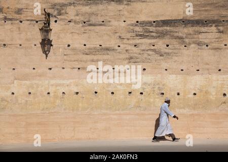 Lone uomo con cappello kufi sulla sua testa a piedi nel pomeriggio scenario delle mura della città in zona di Bab Mechouar e Bab Dekkakin a Fes (Fez), Marocco Foto Stock