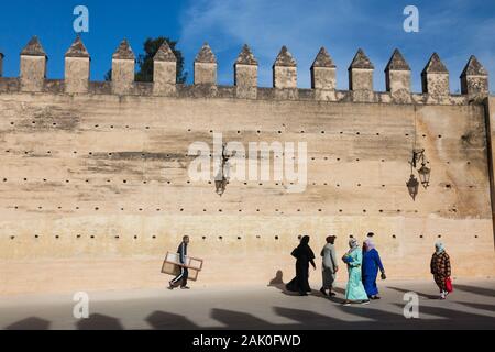 Pedoni nel pomeriggio scenario di terra sbattuta le mura della città con lacune e merli nella zona di Bab Mechouar e Bab Dekkakin in Fes (fez), Marocco Foto Stock