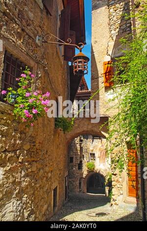 Bel borgo medievale, villaggio isorico in montagna con case con muri in pietra e fiori nelle finestre, strade acciottolate Foto Stock