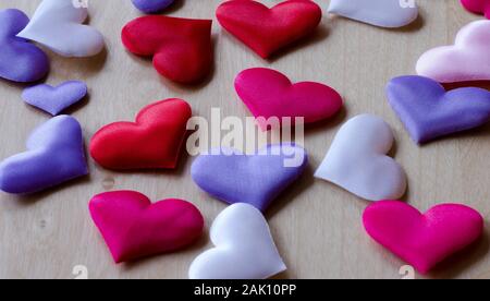 Cuori in diversi colori e dimensioni su di un tavolo di legno Foto Stock