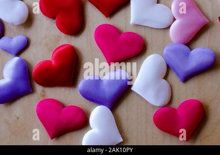 Cuori in diversi colori e dimensioni su di un tavolo di legno Foto Stock