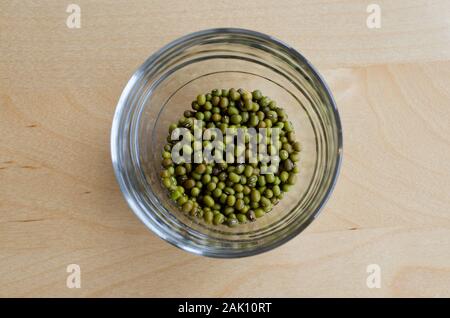 Mungbeans in un bicchiere su un tavolo di legno. Foto Stock