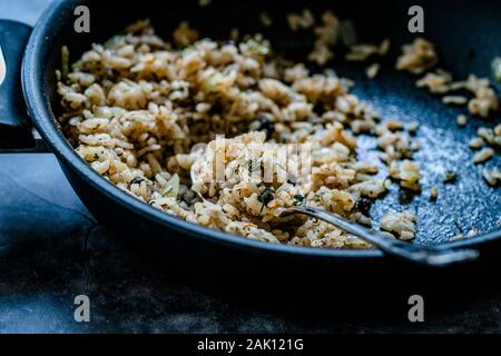 Turco di riso farciti con uve secche di Corinto per preparare Dolma in padella con cucchiaio / Pilav o Pilaf. I cibi tradizionali. Foto Stock