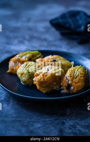 Fiori di zucca ripieni Dolma con riso Pilaf / cibo turco nella piastra. Tradizionale cibo organico. Foto Stock