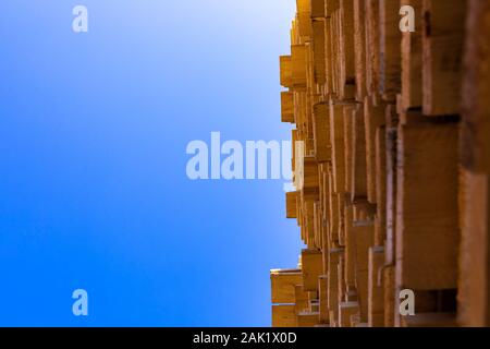 Una vista dritto fino alle estremità degli assi di pino stoccati nel cortile di un costruttore di merchant. Le materie prime utilizzate per la produzione di legname e di quadro di falegnameria Foto Stock