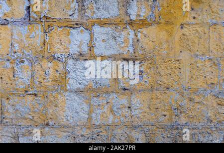 Grunge vecchio muro di mattoni dipinto di giallo il colore dello sfondo e texture. Foto Stock