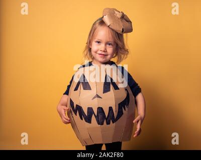 Studio shot di un piccolo bambino vestito come una zucca Foto Stock