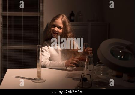 Carino teen ragazza seduta a un tavolo in laboratorio Foto Stock