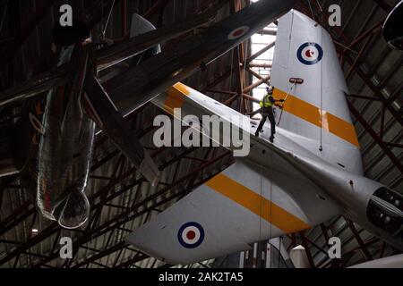 Gli operatori specializzati presso il Royal Air Force Museum Cosford, vicino a Telford, Shropshire, pulire la sospesa Hawker Hunter aeromobile visualizzato all'interno del Museo Nazionale della Guerra Fredda Esposizione, durante l'annuale ad alto livello di pulizia degli aeromobili e la manutenzione. Foto Stock