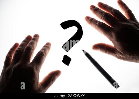 Il simbolo del punto interrogativo scritto su una superficie retroilluminata Foto Stock