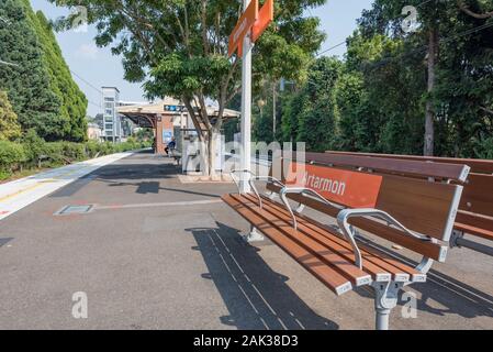 Moderni posti a sedere e una piattaforma di alberi in Artarmon stazione ferroviaria, uno degli originali North Shore stazioni della linea costruita come una singola piattaforma di linea nel 1916 Foto Stock