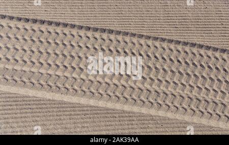 Tracce di pneumatici nella sabbia sulla spiaggia Foto Stock